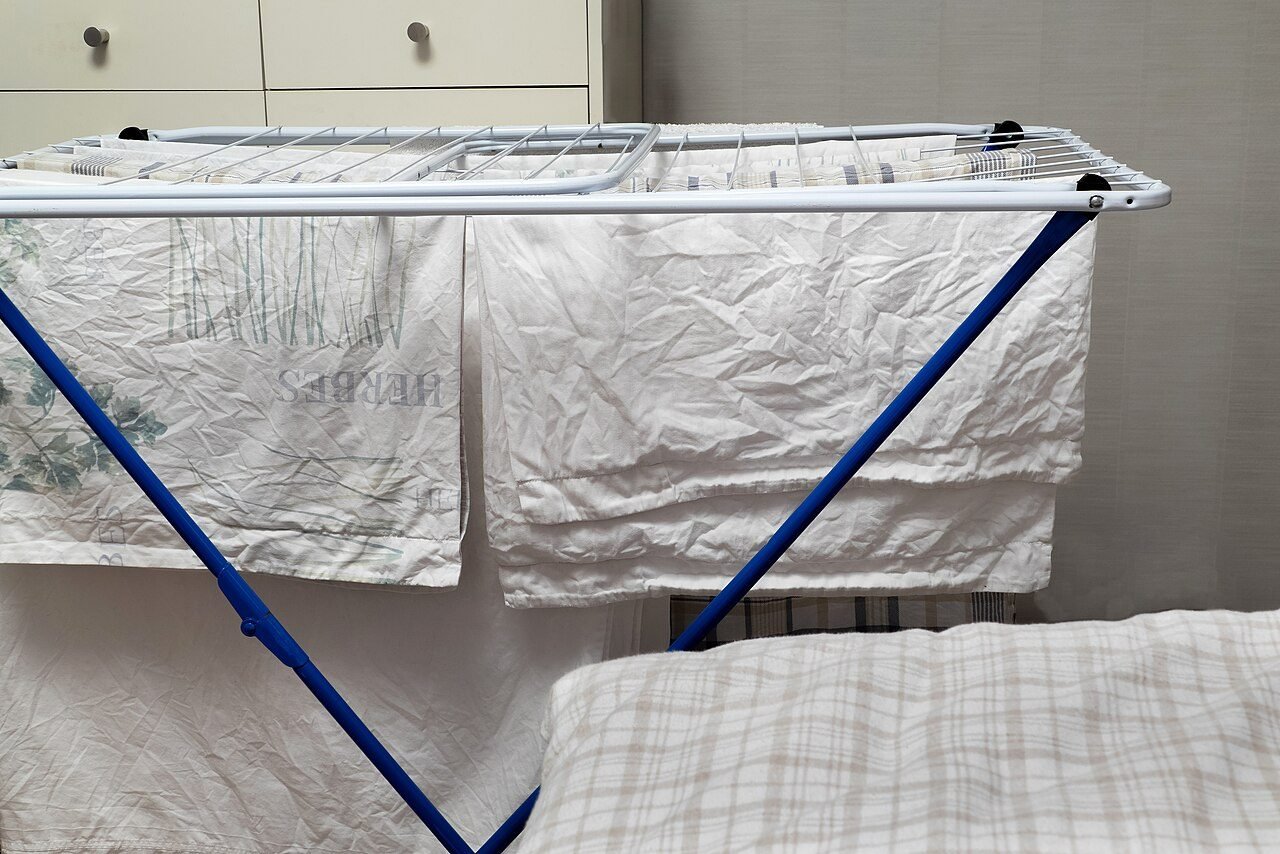 White laundry drying on a folding rack
