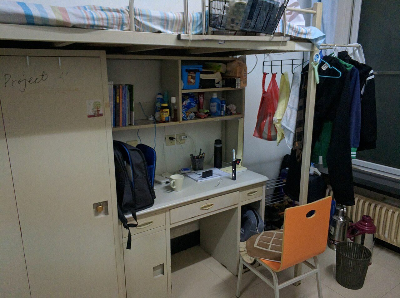Student desk with a laptop in a dorm room